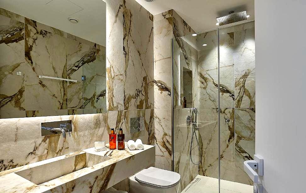 luxurious bathroom with marble walls and modern shower