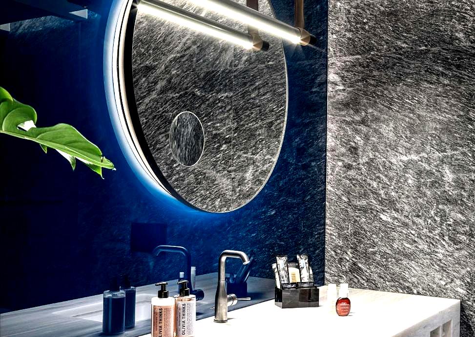 marble bathroom with illuminated mirror and luxury amenities