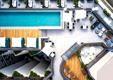 rooftop pool with lounge chairs and sea view