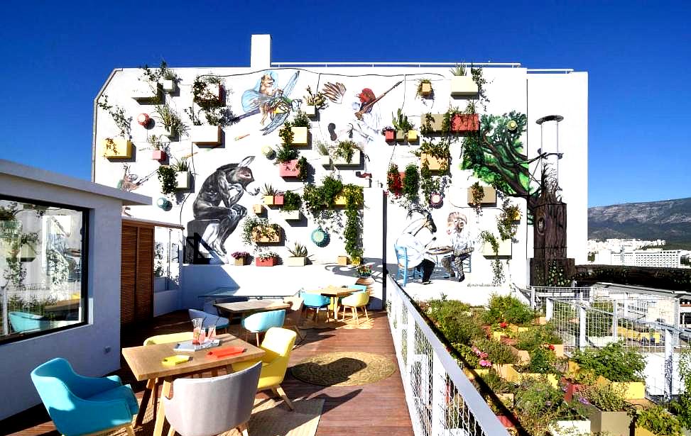 rooftop terrace with artistic wall and urban garden