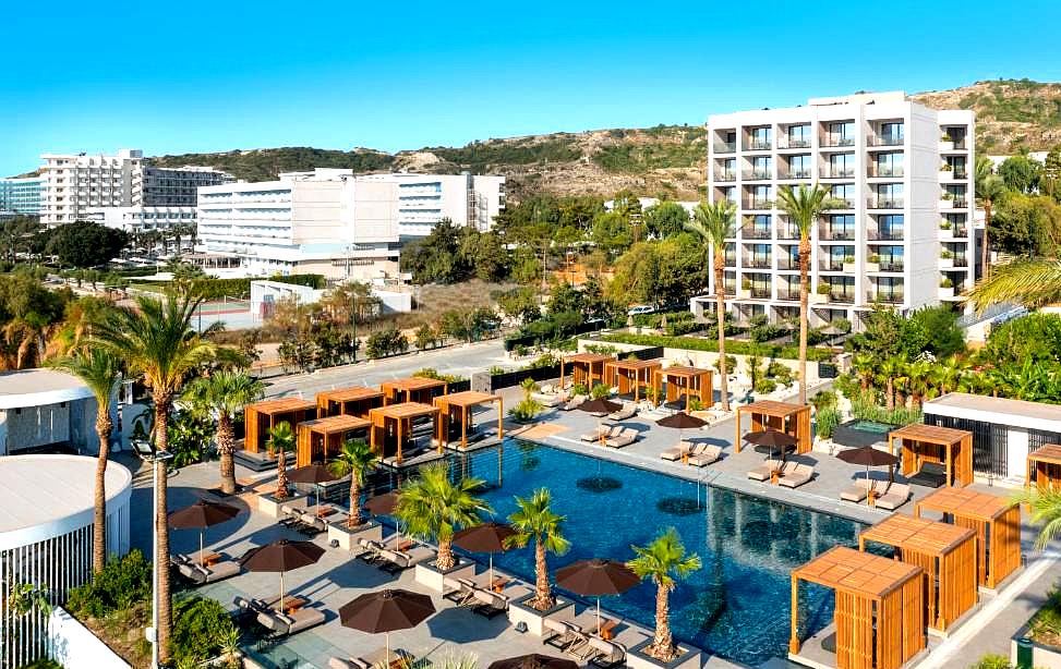 aerial view of luxury hotel pool with cabanas and palm trees