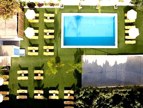 aerial view of outdoor swimming pool with loungers and umbrellas