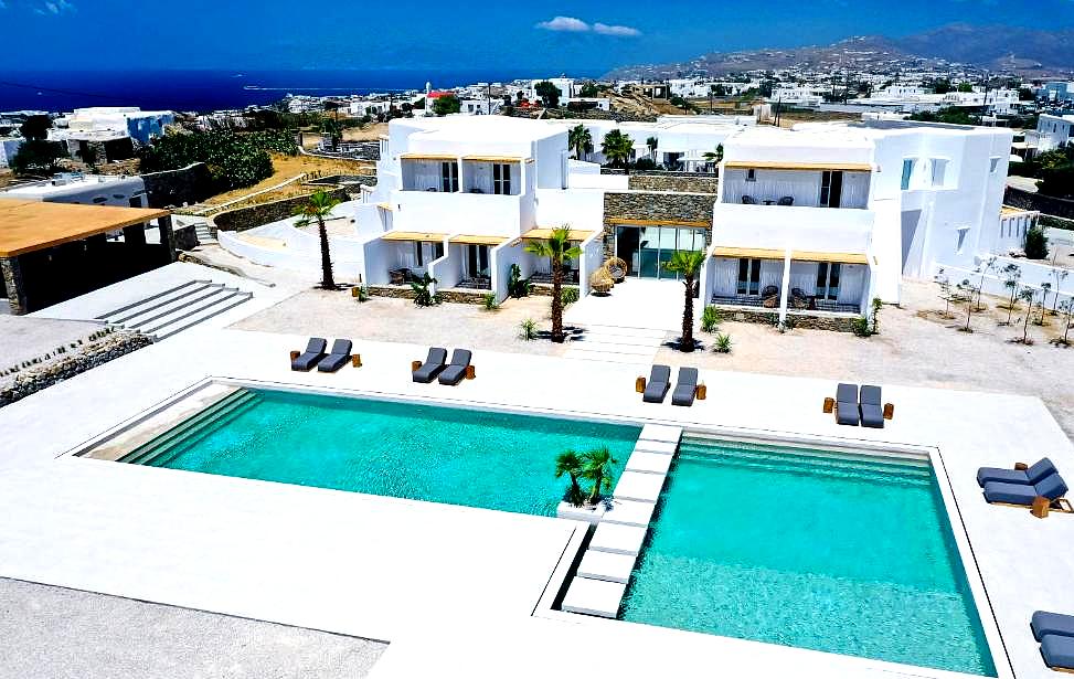 aerial view of pool area with modern white buildings and sea view