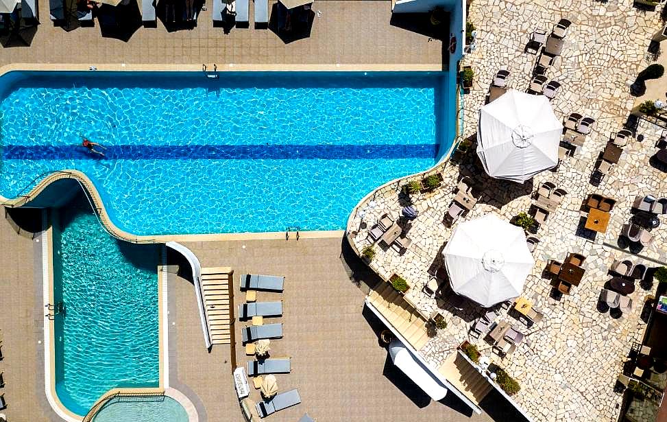 aerial view of pool area with sun loungers and umbrellas