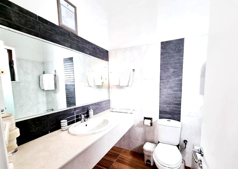 bright bathroom with large mirror and black accents