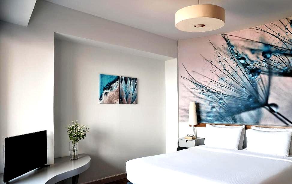 bright bedroom with artwork and sea view