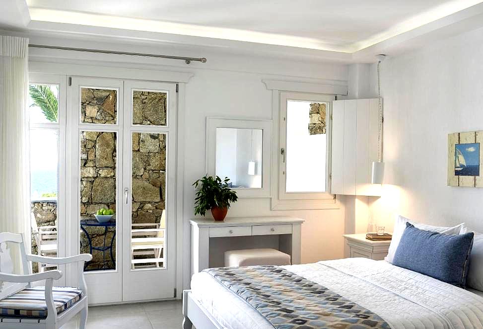 bright bedroom with balcony and stone wall detail