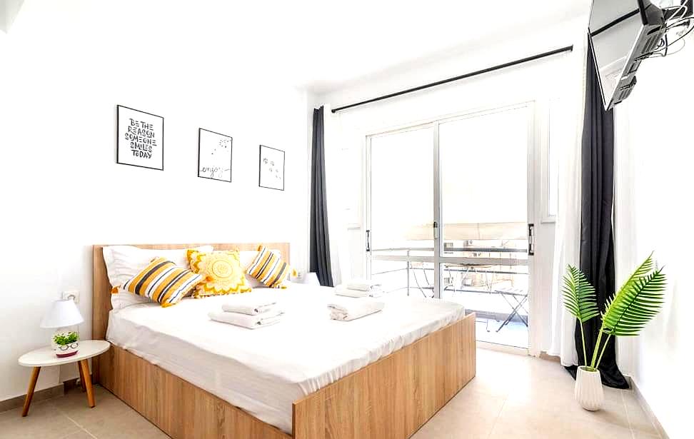 bright bedroom with wooden bed and sea view balcony