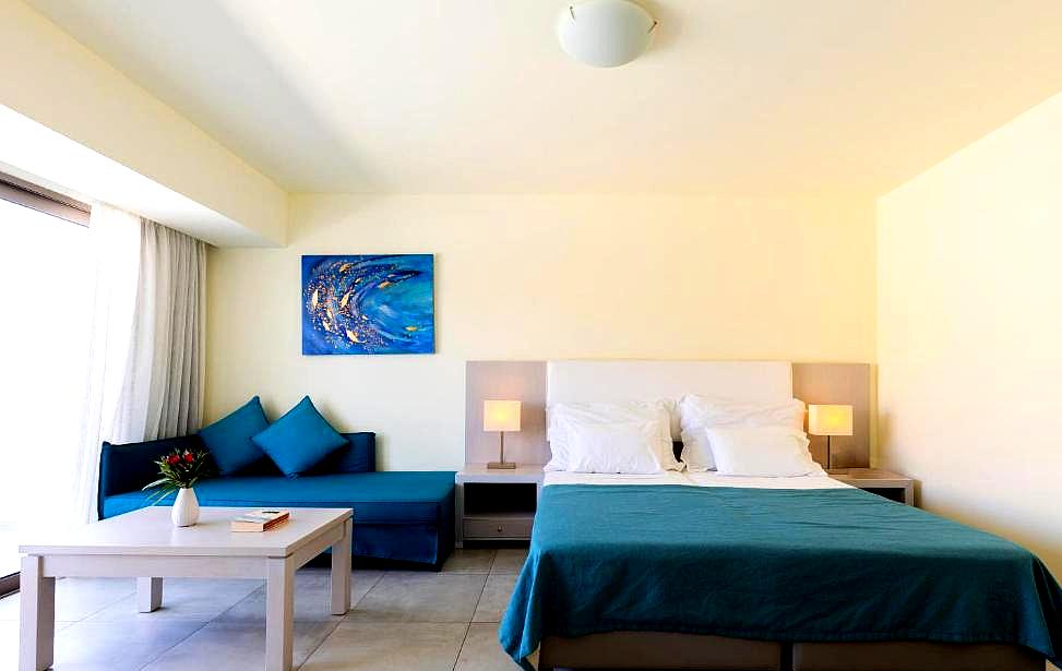 bright hotel room with blue decor and comfortable seating