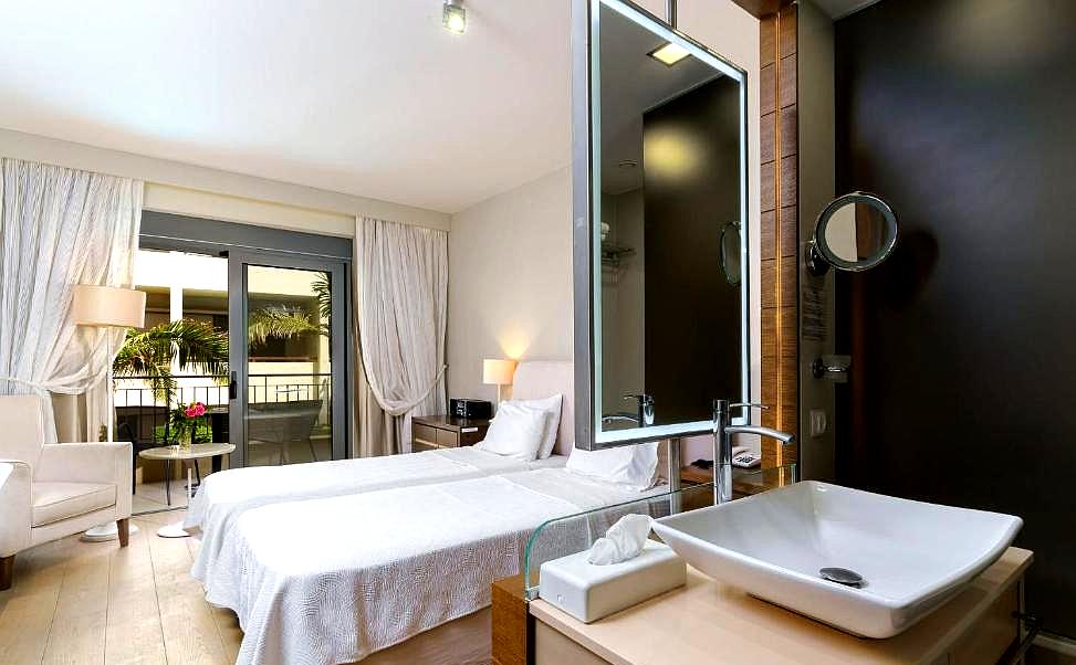 bright hotel room with two beds and private balcony