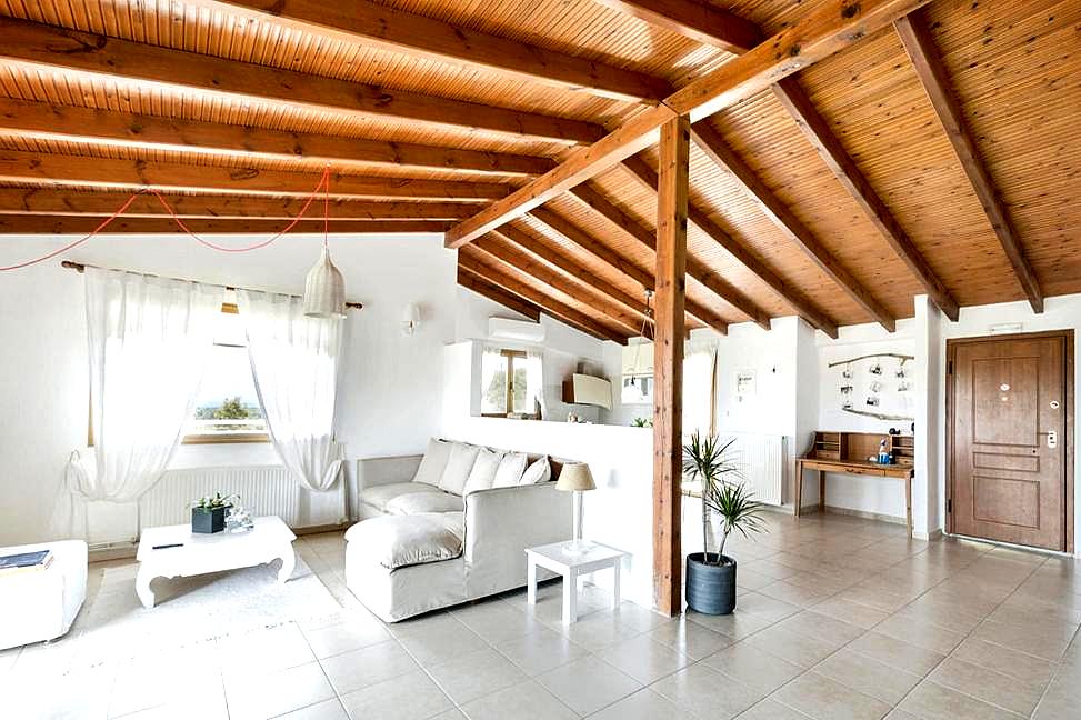 bright living area with exposed wooden beams and natural light