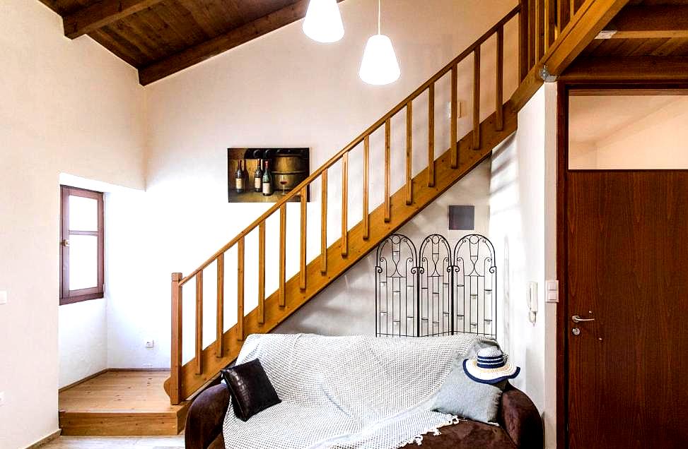 charming duplex room with wooden stairs and cozy sofa