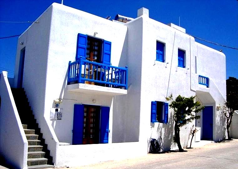 charming white building with blue balconies and stairs