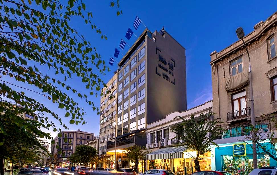 city hotel exterior at dusk with flags and street view