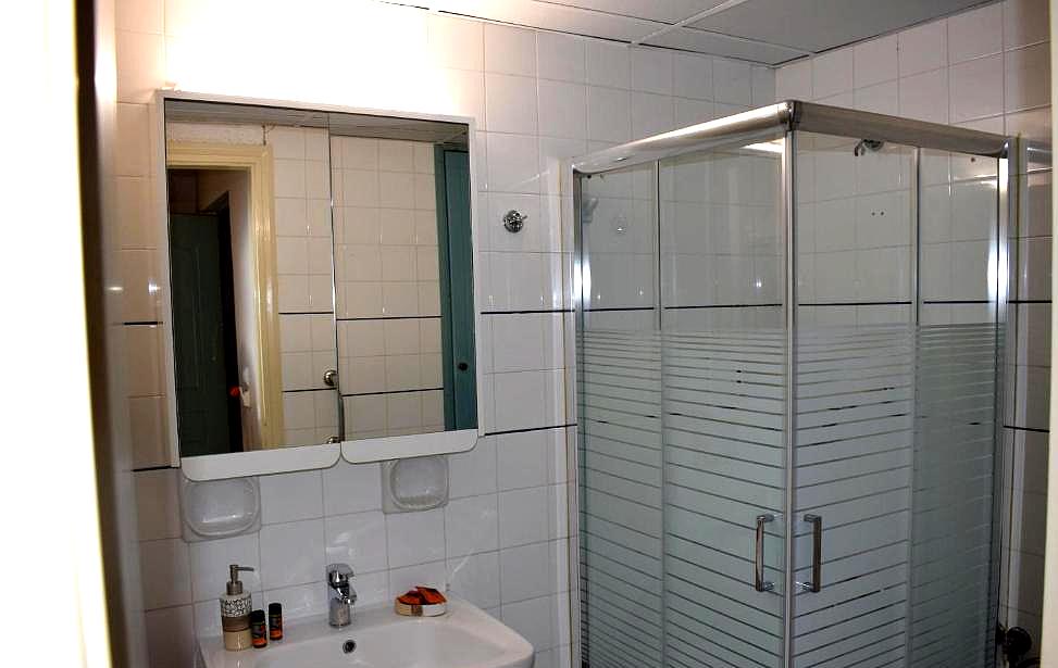 clean tiled bathroom with glass shower enclosure