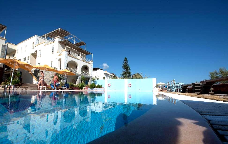 close up of poolside area with people and sun loungers