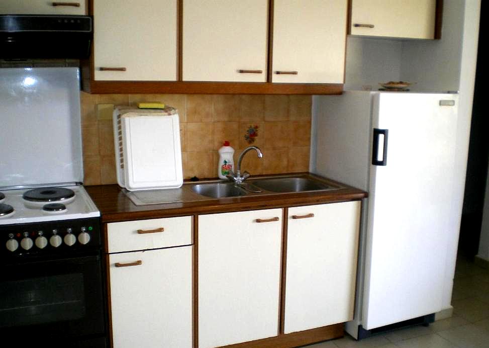 compact kitchenette with basic appliances and storage