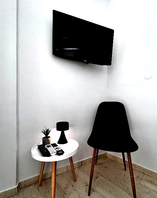 compact meeting space with black chair and mounted tv