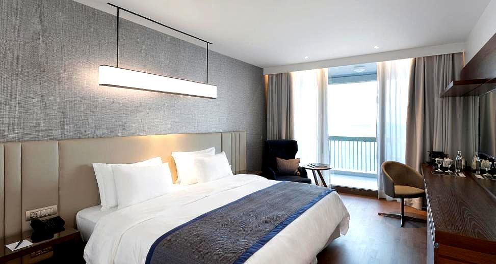 contemporary hotel room with sea view and plush bedding