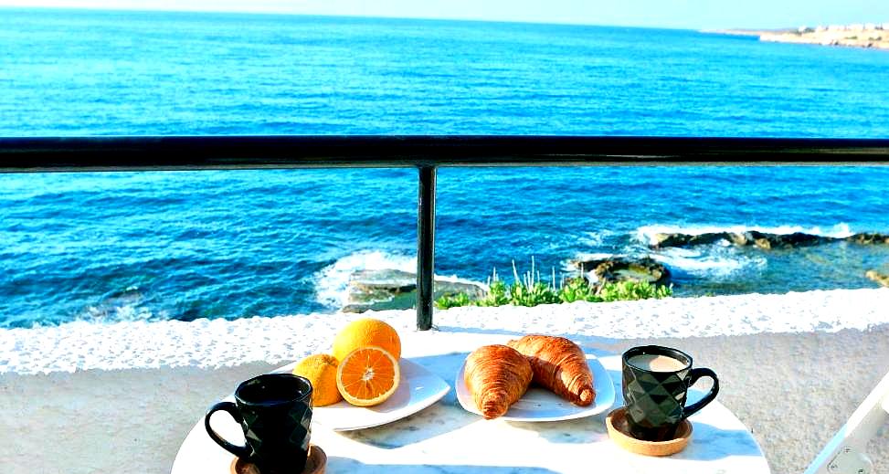 cozy balcony breakfast with sea view and fresh pastries