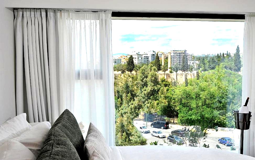 cozy bedroom with large window and stunning city view