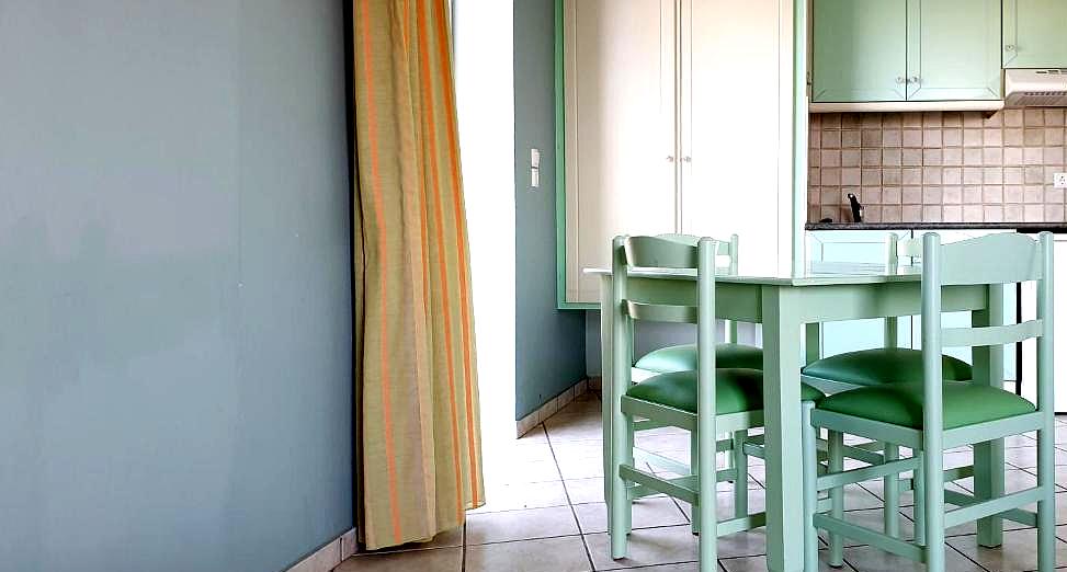 cozy dining area with green decor and kitchenette