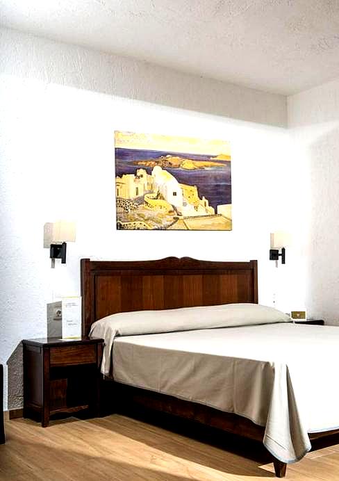 cozy hotel room with dark wood furniture and wall art