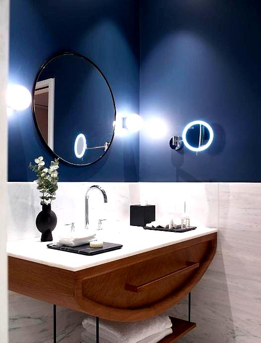 elegant bathroom with blue walls and round mirror