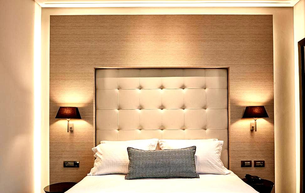 elegant hotel room with padded headboard and warm lighting