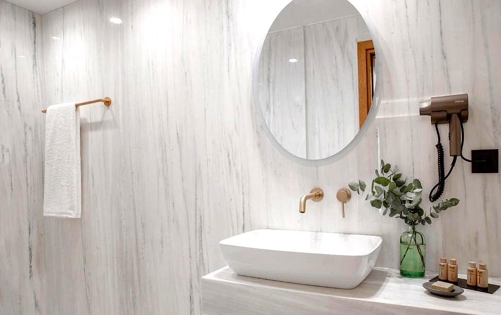 elegant marble bathroom with modern fixtures and round mirror