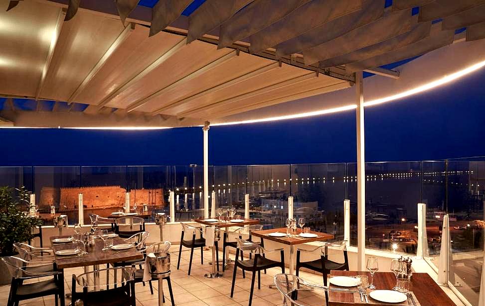 elegant rooftop restaurant with sea view and night lighting