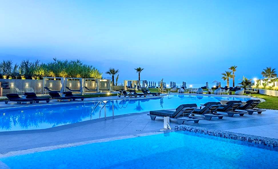 evening poolside at luxury hotel with infinity pool and lounge chairs