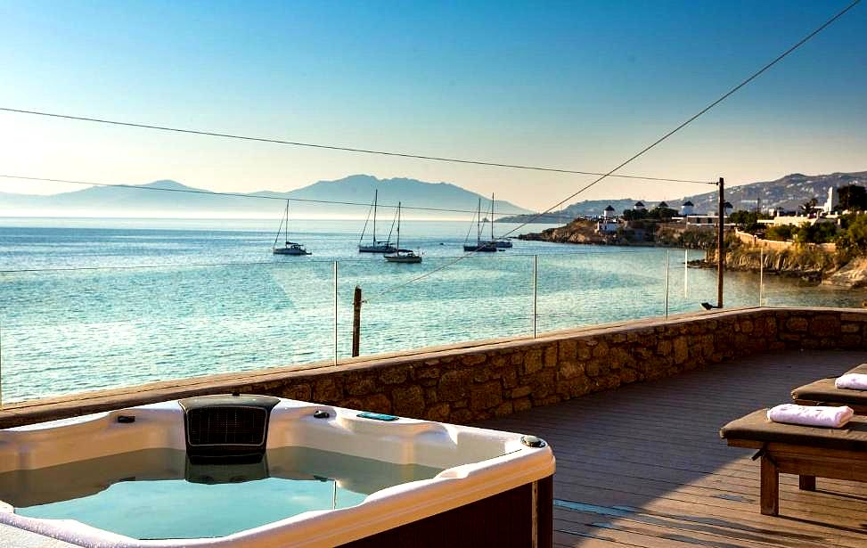 hot tub and lounge area with stunning sea view