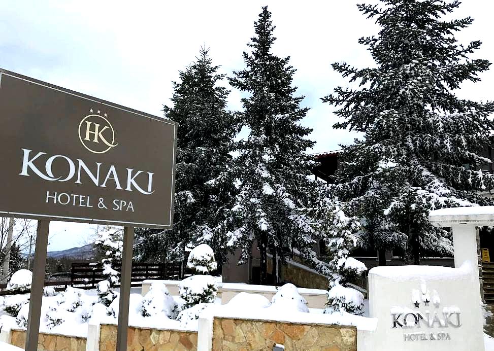 hotel entrance with signage and snow covered pine trees