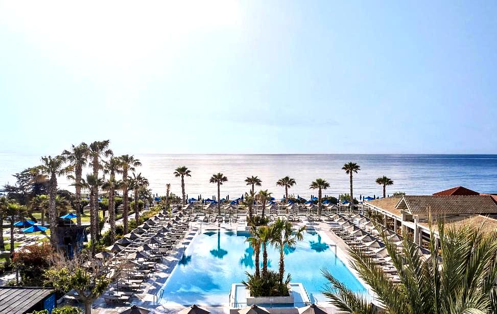 hotel poolside with sea view and palm trees