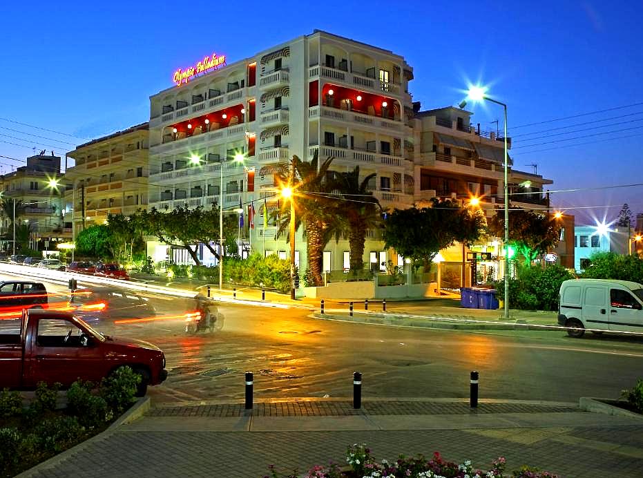 illuminated hotel exterior at night with bustling street view