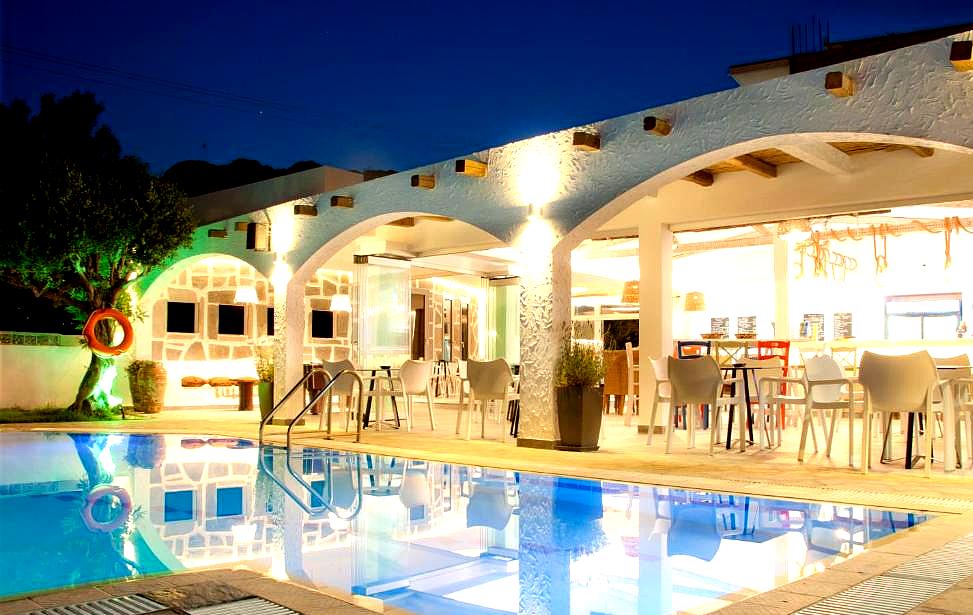 illuminated hotel pool area with dining space at night