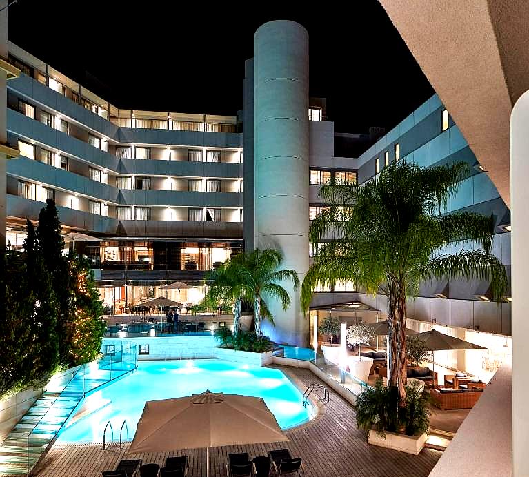 illuminated hotel pool area with palm trees