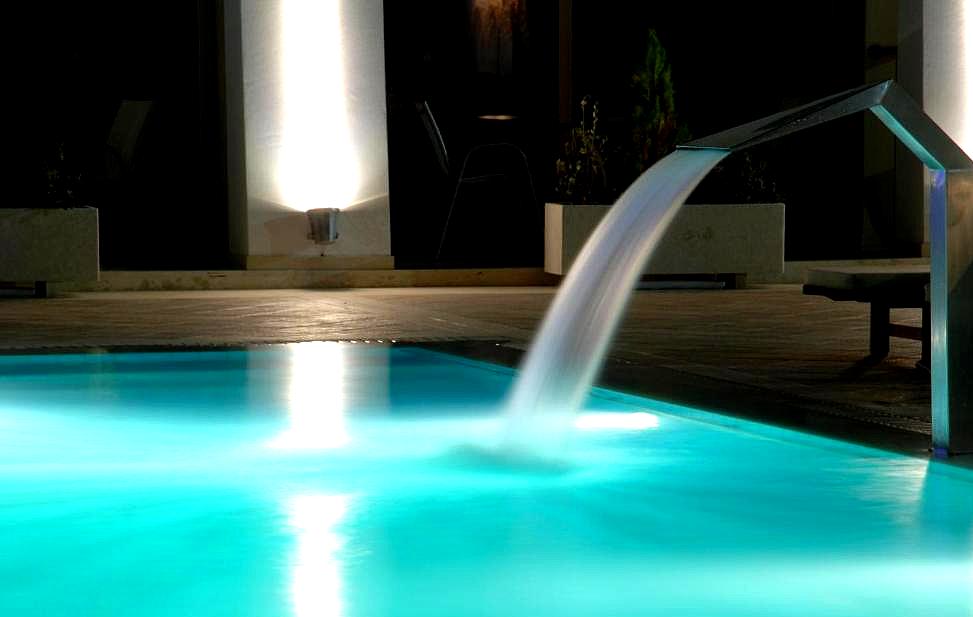 illuminated night pool with waterfall feature