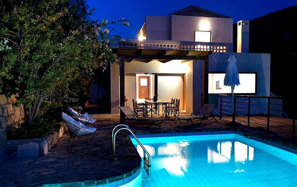 illuminated poolside patio at night with lush vegetation