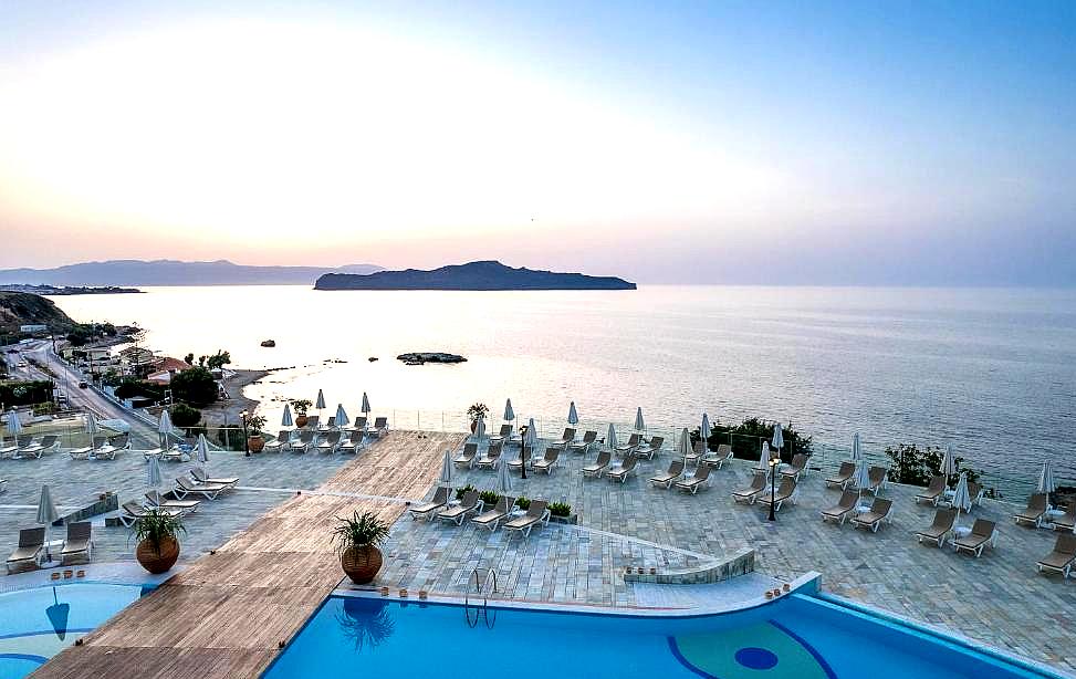 infinity pool overlooking sea at sunset