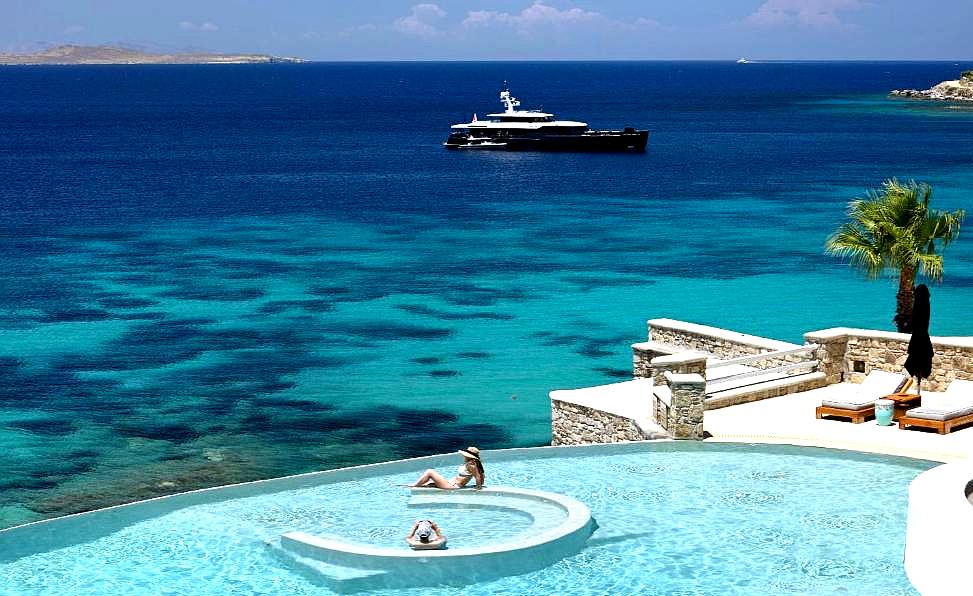 infinity pool with sea view and lounge chairs