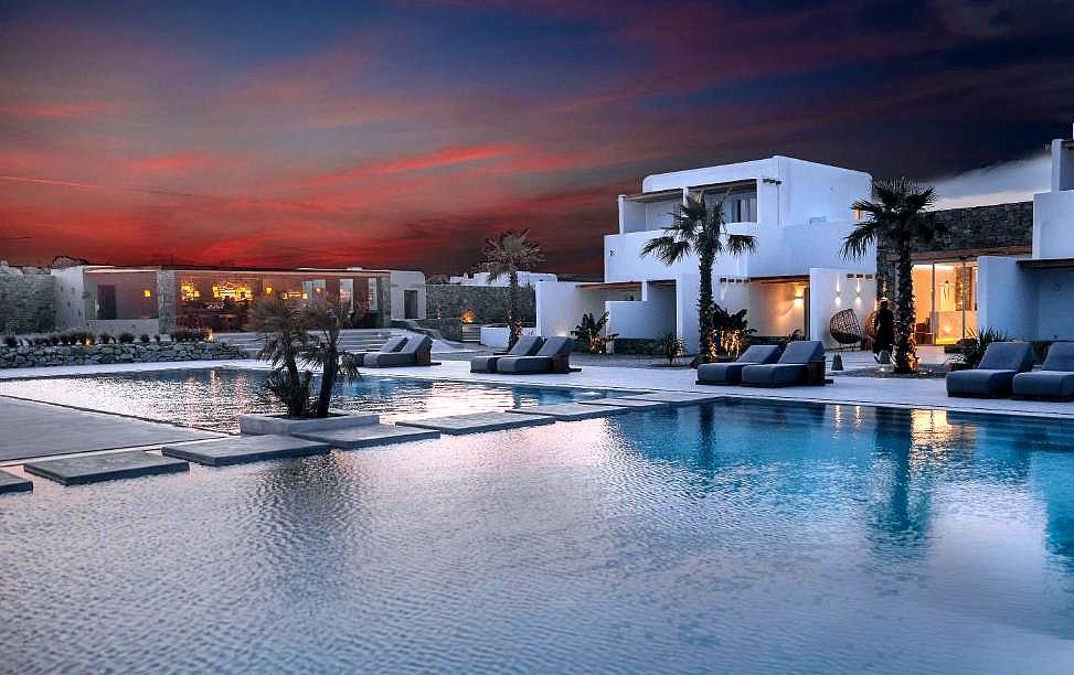 large outdoor pool at dusk with modern villas