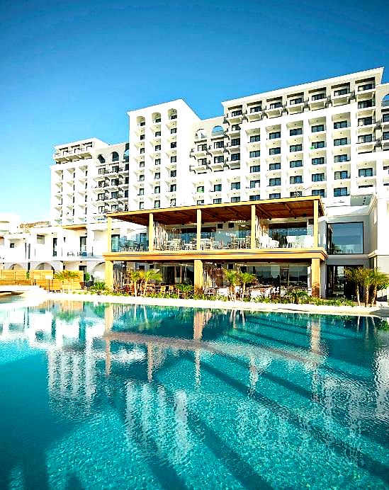 large outdoor pool with hotel building in background