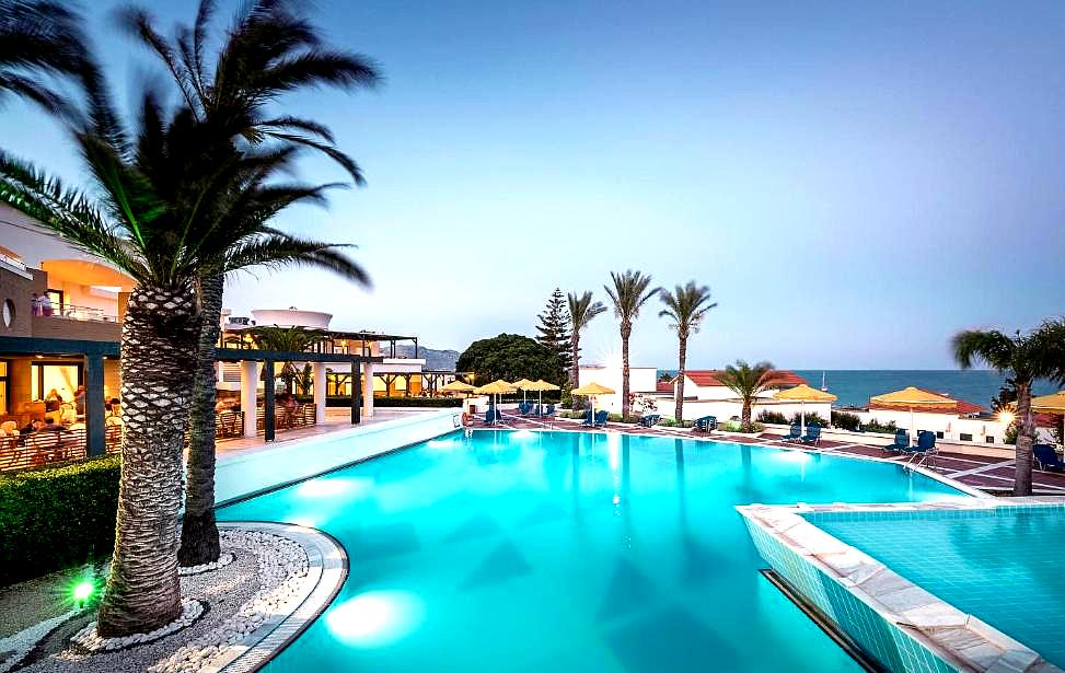 large outdoor pool with palm trees and sea view