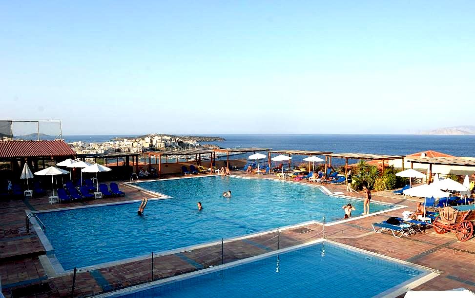 large outdoor pool with sun loungers and sea view