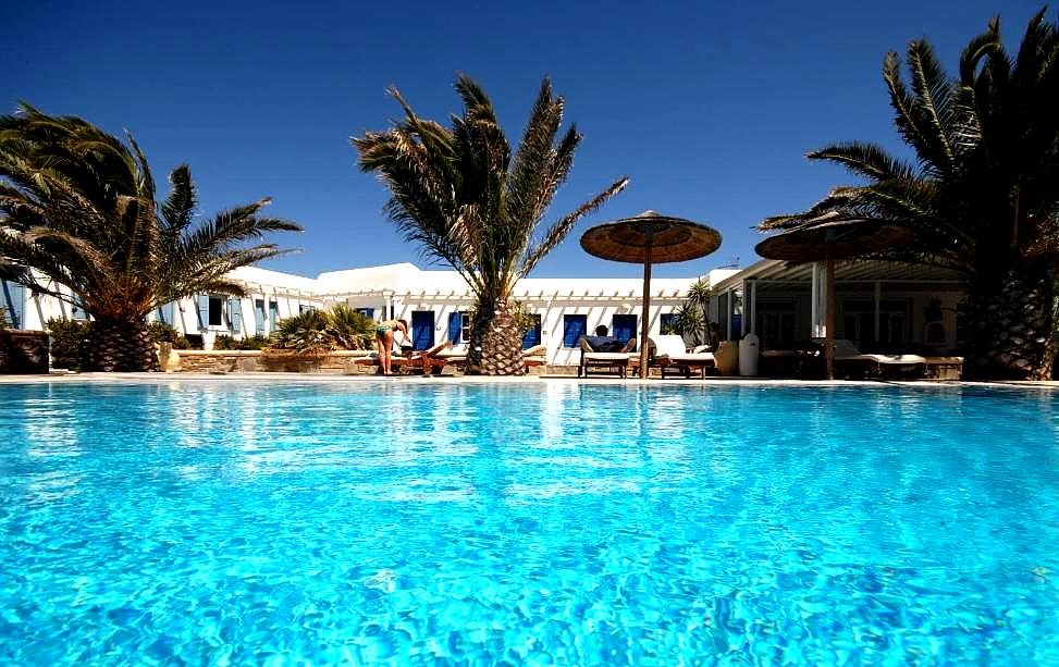 large pool with cabanas and palm trees