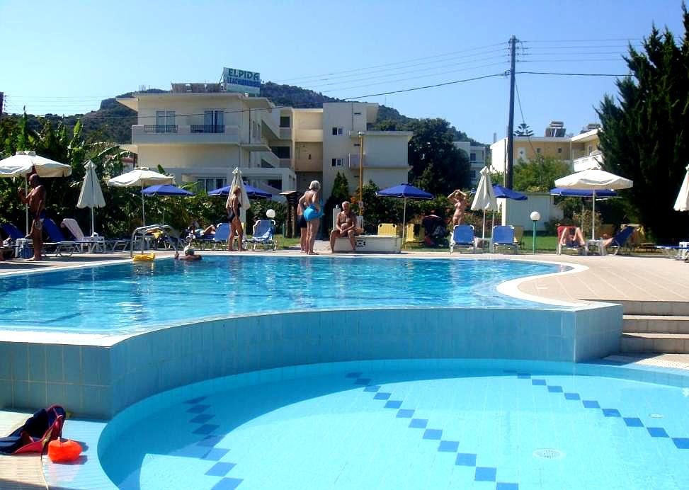 lively outdoor pool area with sun loungers and umbrellas