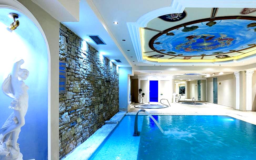 luxurious indoor pool with elegant statues and ornate ceiling