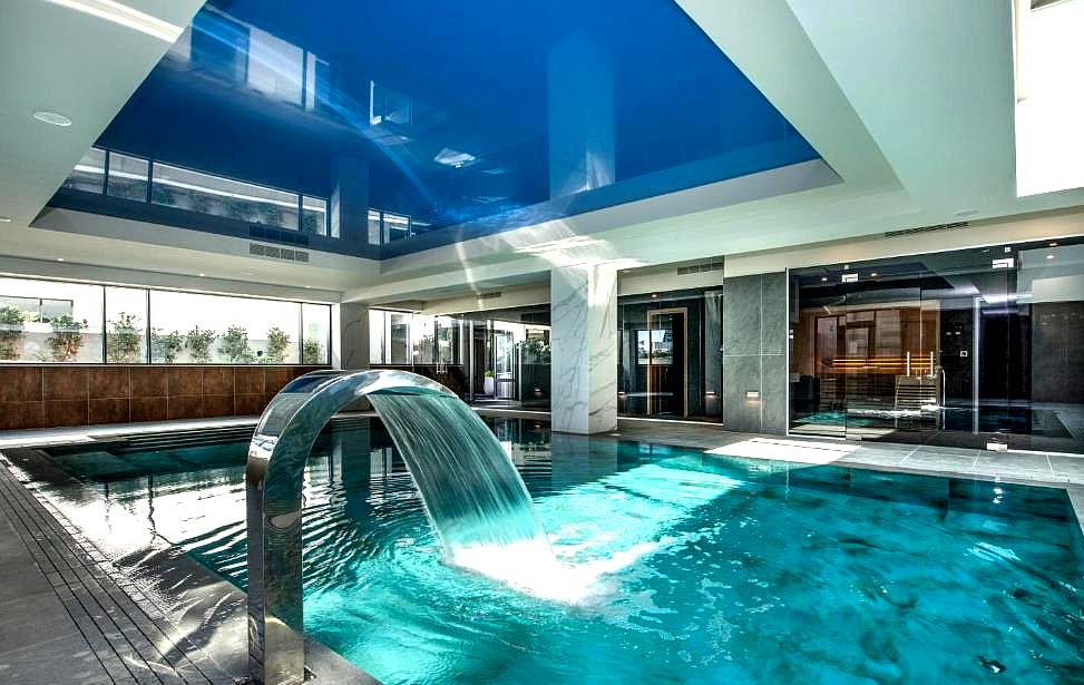 luxurious indoor pool with waterfall feature and modern design